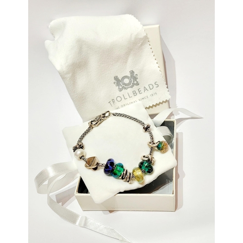 36 - A FANTASTIC TROLLBEADS STERLING SILVER BRACELET WITH CHARMS, presented in original box on a soft rib... 