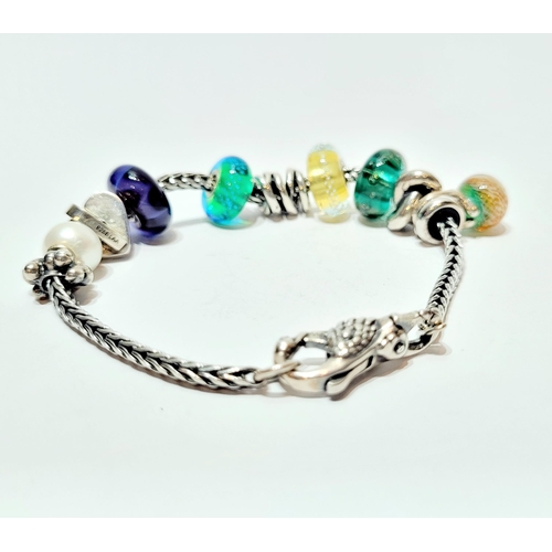 36 - A FANTASTIC TROLLBEADS STERLING SILVER BRACELET WITH CHARMS, presented in original box on a soft rib... 