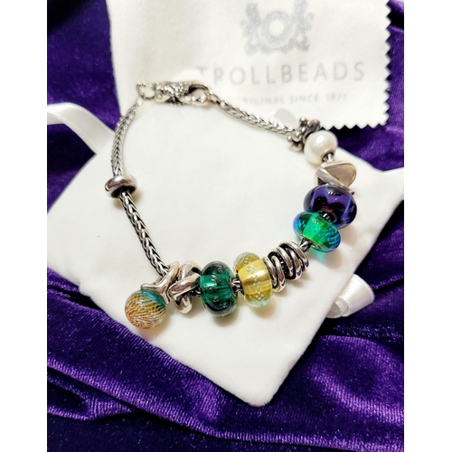 36 - A FANTASTIC TROLLBEADS STERLING SILVER BRACELET WITH CHARMS, presented in original box on a soft rib... 