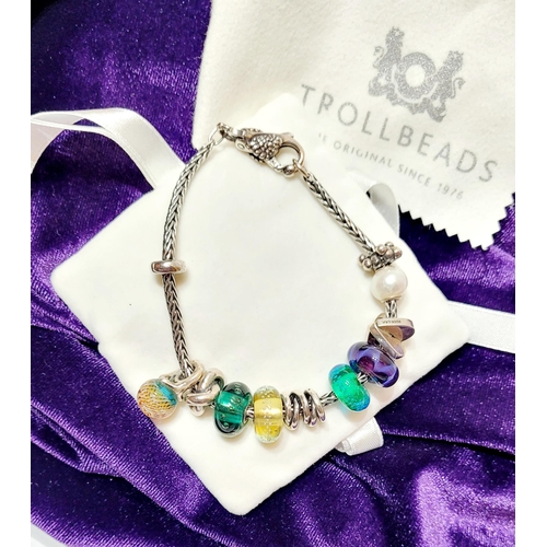 36 - A FANTASTIC TROLLBEADS STERLING SILVER BRACELET WITH CHARMS, presented in original box on a soft rib... 