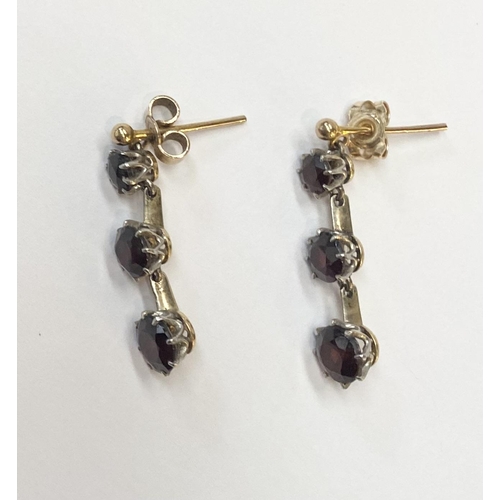 39 - A BEAUTIFUL PAIR OF 9CT GOLD THREE STONE GARNET DROP EARRINGS, clasps marked 9ct, the earrings featu... 