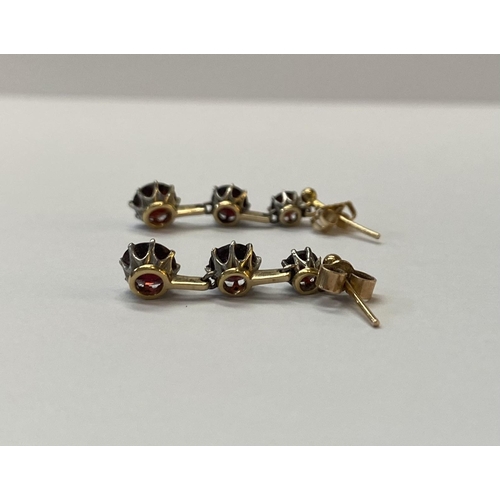 39 - A BEAUTIFUL PAIR OF 9CT GOLD THREE STONE GARNET DROP EARRINGS, clasps marked 9ct, the earrings featu... 