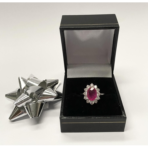 61 - AN EXCEPTIONAL 18CT WHITE GOLD RUBY AND DIAMOND CLUSTER RING, central vibrant ruby in four claw sett... 