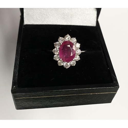 61 - AN EXCEPTIONAL 18CT WHITE GOLD RUBY AND DIAMOND CLUSTER RING, central vibrant ruby in four claw sett... 