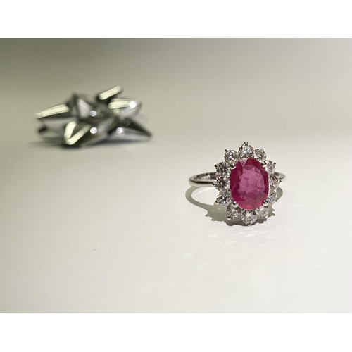 61 - AN EXCEPTIONAL 18CT WHITE GOLD RUBY AND DIAMOND CLUSTER RING, central vibrant ruby in four claw sett... 