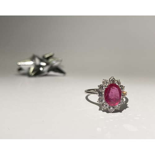 61 - AN EXCEPTIONAL 18CT WHITE GOLD RUBY AND DIAMOND CLUSTER RING, central vibrant ruby in four claw sett... 