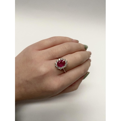 61 - AN EXCEPTIONAL 18CT WHITE GOLD RUBY AND DIAMOND CLUSTER RING, central vibrant ruby in four claw sett... 