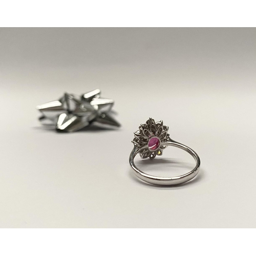 61 - AN EXCEPTIONAL 18CT WHITE GOLD RUBY AND DIAMOND CLUSTER RING, central vibrant ruby in four claw sett... 