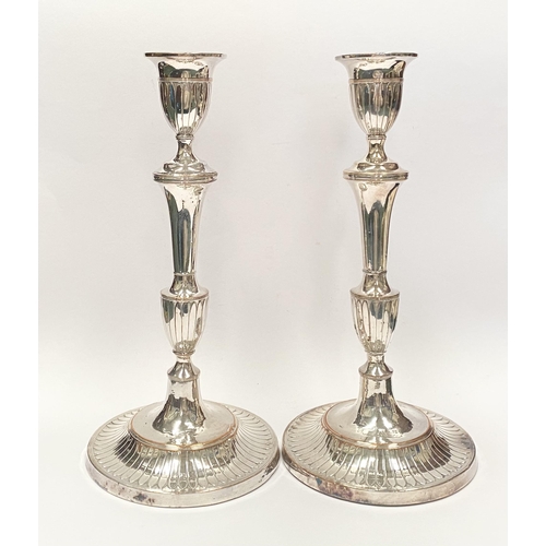 67 - A PAIR OF DECORATIVE GEORGE V STYLE SILVER PLATED CANDLESTICKS, with fluting to urn shaped sockets, ... 