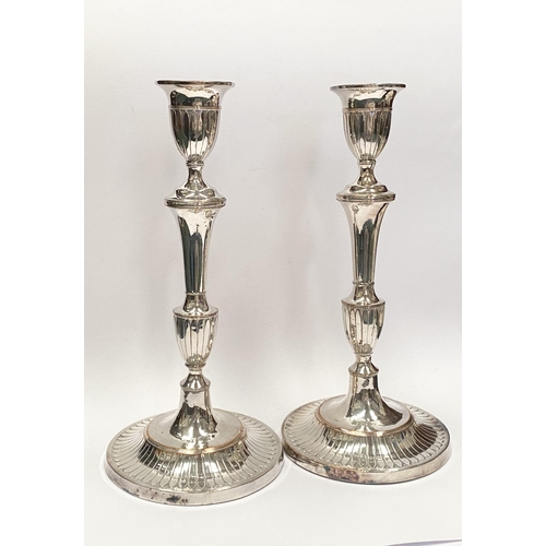 67 - A PAIR OF DECORATIVE GEORGE V STYLE SILVER PLATED CANDLESTICKS, with fluting to urn shaped sockets, ... 