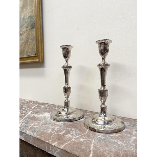 67 - A PAIR OF DECORATIVE GEORGE V STYLE SILVER PLATED CANDLESTICKS, with fluting to urn shaped sockets, ... 