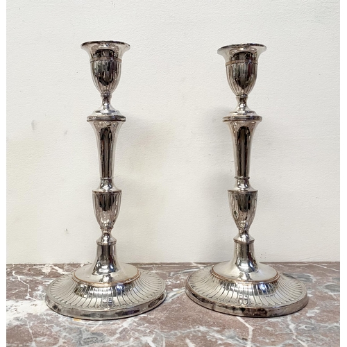 67 - A PAIR OF DECORATIVE GEORGE V STYLE SILVER PLATED CANDLESTICKS, with fluting to urn shaped sockets, ... 