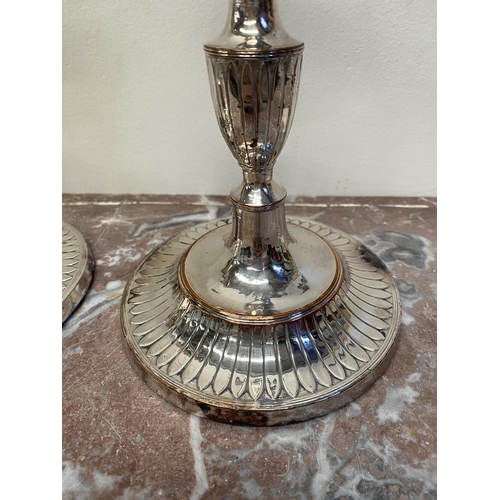 67 - A PAIR OF DECORATIVE GEORGE V STYLE SILVER PLATED CANDLESTICKS, with fluting to urn shaped sockets, ... 