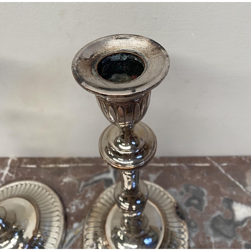 67 - A PAIR OF DECORATIVE GEORGE V STYLE SILVER PLATED CANDLESTICKS, with fluting to urn shaped sockets, ... 