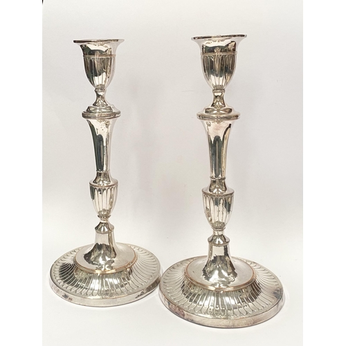 67 - A PAIR OF DECORATIVE GEORGE V STYLE SILVER PLATED CANDLESTICKS, with fluting to urn shaped sockets, ... 