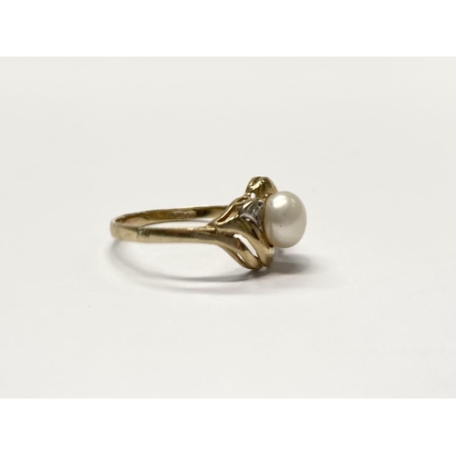 69 - A BEAUTIFUL 9CT YELLOW GOLD PEARL CROSSOVER RING, with central pearl within two tone decorative cros... 