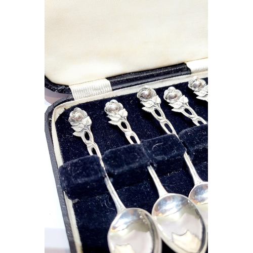 7 - AN EARLY 20TH CENTURY CASED SET OF SILVER ROSE TIPPED TEA SPOONS, each handle with an intertwining r... 