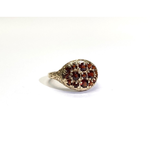 73 - A VINTAGE 9CT YELLOW GOLD GARNET CLUSTER RING, with fifteen round cut garnets of varying sizes claw ... 