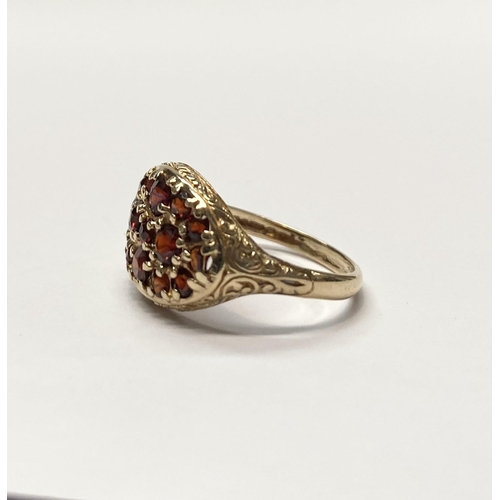 73 - A VINTAGE 9CT YELLOW GOLD GARNET CLUSTER RING, with fifteen round cut garnets of varying sizes claw ... 