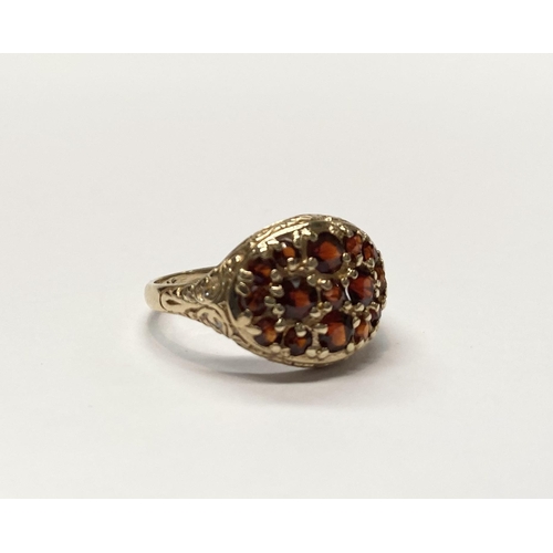 73 - A VINTAGE 9CT YELLOW GOLD GARNET CLUSTER RING, with fifteen round cut garnets of varying sizes claw ... 