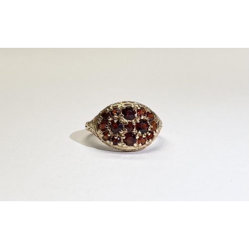 73 - A VINTAGE 9CT YELLOW GOLD GARNET CLUSTER RING, with fifteen round cut garnets of varying sizes claw ... 