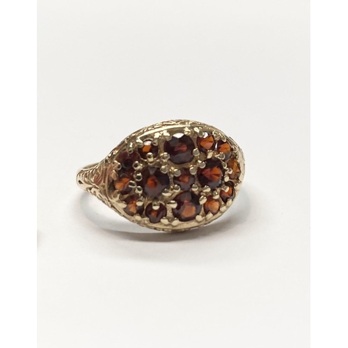 73 - A VINTAGE 9CT YELLOW GOLD GARNET CLUSTER RING, with fifteen round cut garnets of varying sizes claw ... 