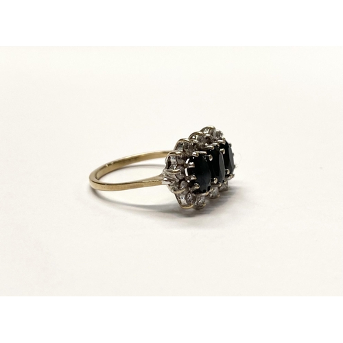 80 - A STRIKING THREE STONE SAPPHIRE CLUSTER RING, with three oval cut sapphires surrounded by eighteen r... 