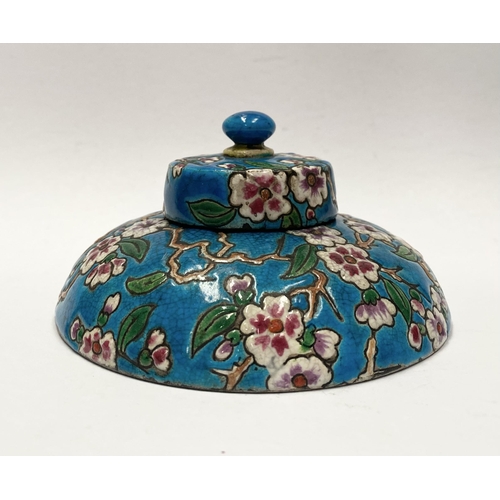 82 - AN EARLY 20TH CENTURY FRENCH POTTERY INKWELL, with cherry blossom design to circular body and cover ... 