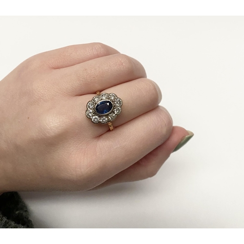 84 - A BEAUTIFUL 18CT YELLOW GOLD SAPPHIRE AND DIAMOND CLUSTER RING, vibrant oval cut bezel set sapphire ... 