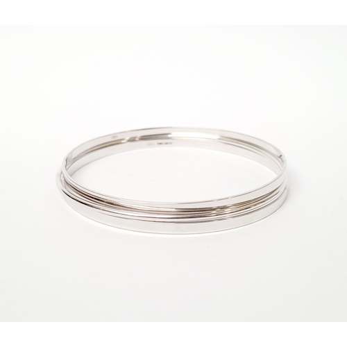 94 - A STUNNING TRIO OF 18CT WHITE GOLD BANGLE BRACLETS, each hallmarked; 18ct white gold. 750. 6cm wide.