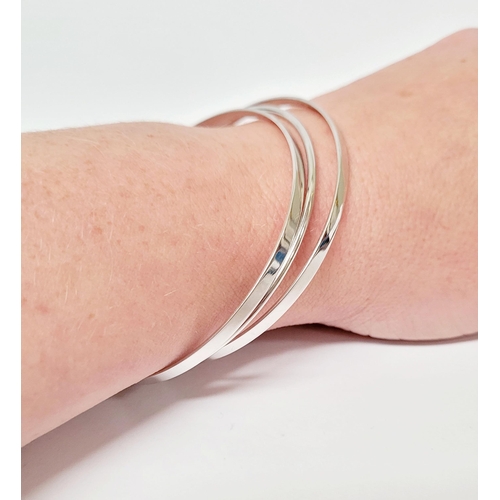 94 - A STUNNING TRIO OF 18CT WHITE GOLD BANGLE BRACLETS, each hallmarked; 18ct white gold. 750. 6cm wide.