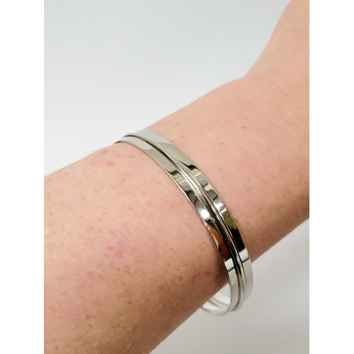 94 - A STUNNING TRIO OF 18CT WHITE GOLD BANGLE BRACLETS, each hallmarked; 18ct white gold. 750. 6cm wide.