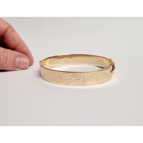 95 - A BEAUTIFUL BRIGHT-CUT DECORATED 9CT YELLOW GOLD BANGLE, the curved bangle is decorated with scrolli... 