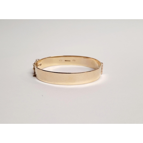 95 - A BEAUTIFUL BRIGHT-CUT DECORATED 9CT YELLOW GOLD BANGLE, the curved bangle is decorated with scrolli... 