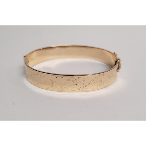 95 - A BEAUTIFUL BRIGHT-CUT DECORATED 9CT YELLOW GOLD BANGLE, the curved bangle is decorated with scrolli... 