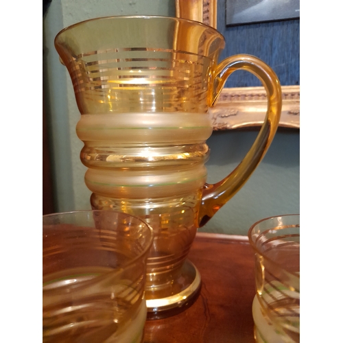 262 - A VINTAGE COLOURED GLASS PITCHER AND THREE GLASSES, each of matching design with fluted body, gilt s... 