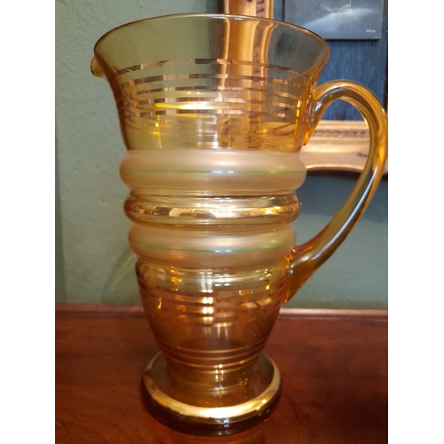 262 - A VINTAGE COLOURED GLASS PITCHER AND THREE GLASSES, each of matching design with fluted body, gilt s... 