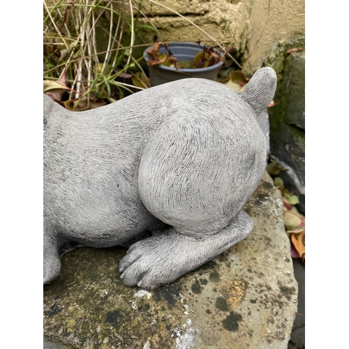 281 - A STONE GARDEN FIGURE IN THE FORM OF PUPPY WITH BOOT, dimensions: 37cm wide approx.