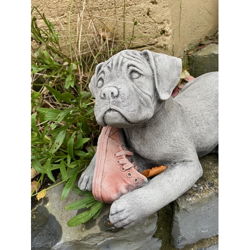 281 - A STONE GARDEN FIGURE IN THE FORM OF PUPPY WITH BOOT, dimensions: 37cm wide approx.