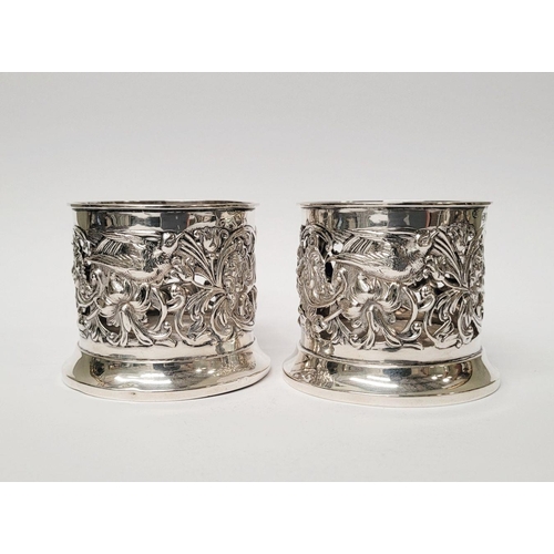 12 - A PAIR OF LATE 19TH CENTURY NEATLY SIZED SOLID SILVER BOTTLE HOLDERS / COASTERS, decorated all over ... 