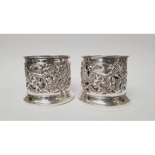 12 - A PAIR OF LATE 19TH CENTURY NEATLY SIZED SOLID SILVER BOTTLE HOLDERS / COASTERS, decorated all over ... 