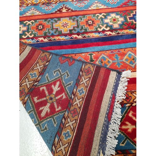 128 - A VIBRANT AFGHAN SHAAL RUNNER RUG, hand knotted, of traditional design with multiple striped geometr... 