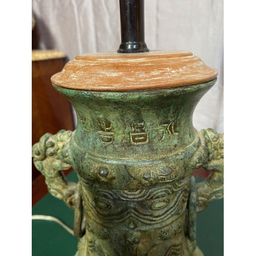 132 - A CHINESE BRONZED METAL URN TABLE LAMP, with double head fitting & adjustable neck, resting on a woo... 