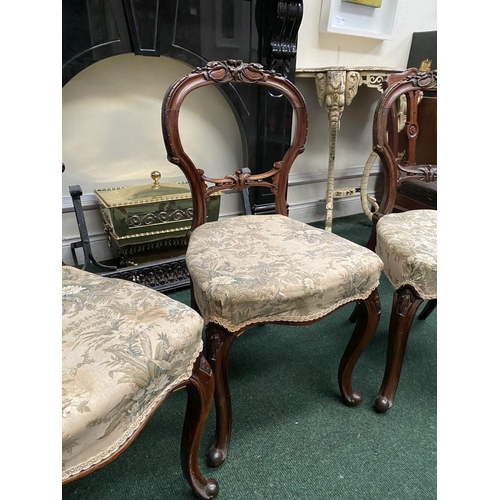 140 - A SET OF THREE EARLY VICTORIAN MAHOGANY DINING CHAIRS, the balloon back with foliate carvings above ... 