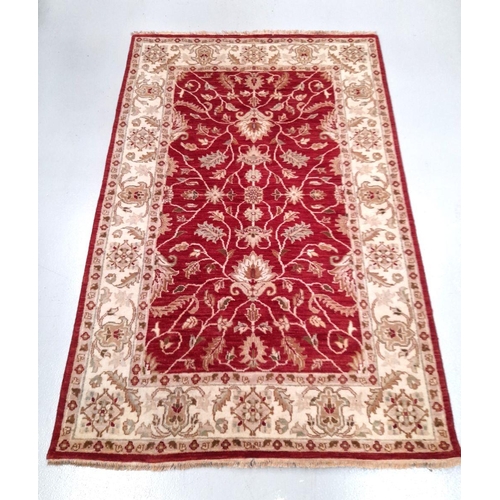 26 - AN EXCELLENT CHOBI CARPET, hand woven, featuring a traditional floral pattern in vibrant deep red an... 