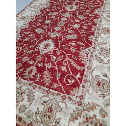 26 - AN EXCELLENT CHOBI CARPET, hand woven, featuring a traditional floral pattern in vibrant deep red an... 