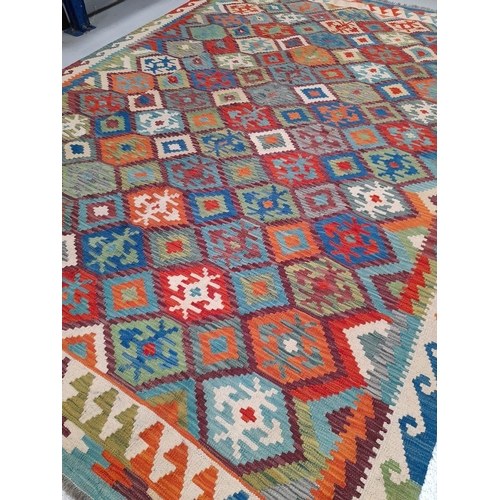 41 - A TRADITIONAL KELLIM RUG, hand woven, featuring diamond pattern with geometric motifs, in vibrant re... 