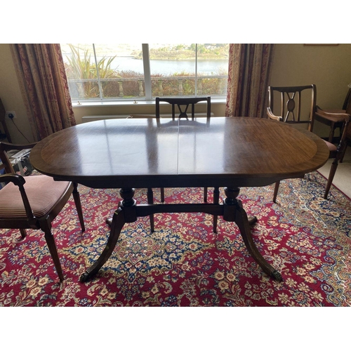 44 - A GOOD MAHOGANY CROSSBANDED EXTENDING DINING TABLE, the oval top with crossbanded border atop turned... 