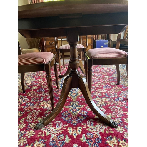 44 - A GOOD MAHOGANY CROSSBANDED EXTENDING DINING TABLE, the oval top with crossbanded border atop turned... 