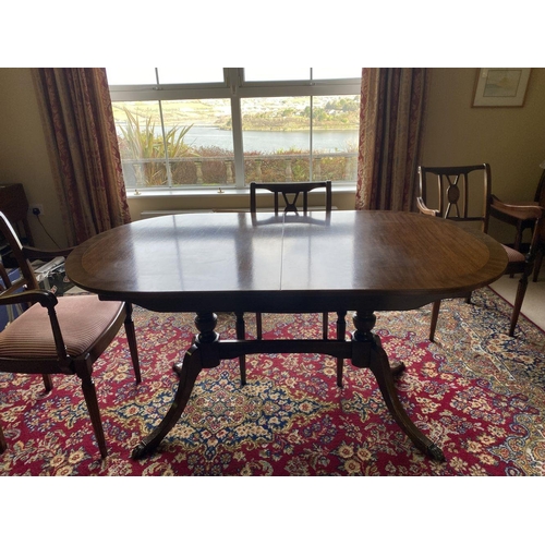 44 - A GOOD MAHOGANY CROSSBANDED EXTENDING DINING TABLE, the oval top with crossbanded border atop turned... 